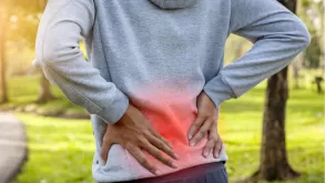 Man Holding His Back With Pain At A Park